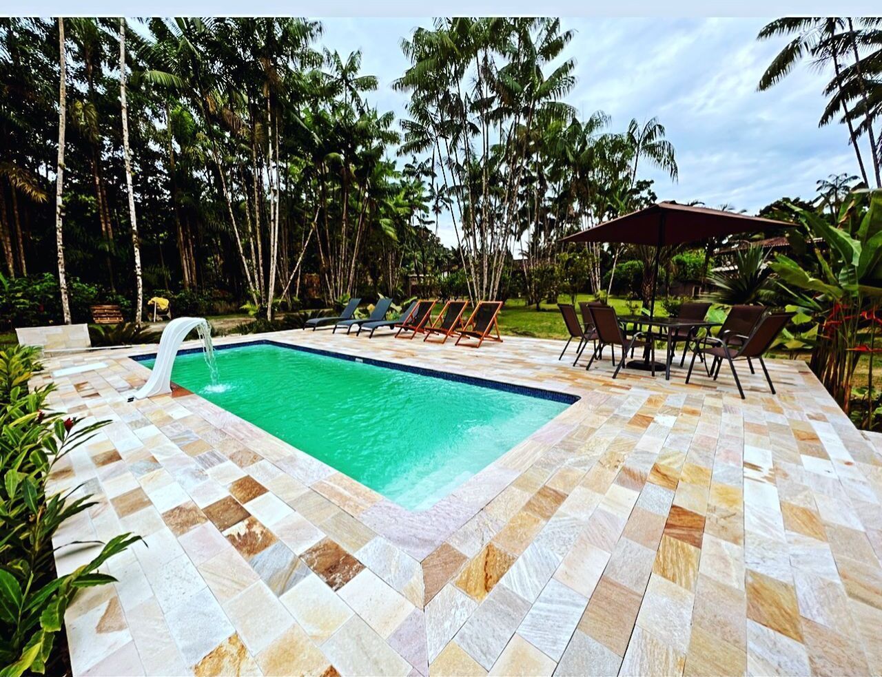 Una piscina al aire libre, sillones reclinables de piscina