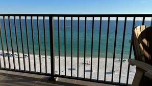 En balkon med udsigt over en strand og havet.
