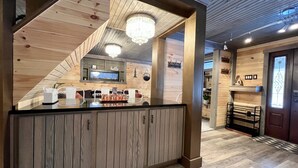 Een houten interieur met een centraal gelegen balie, houten balken en een kroonluchter.