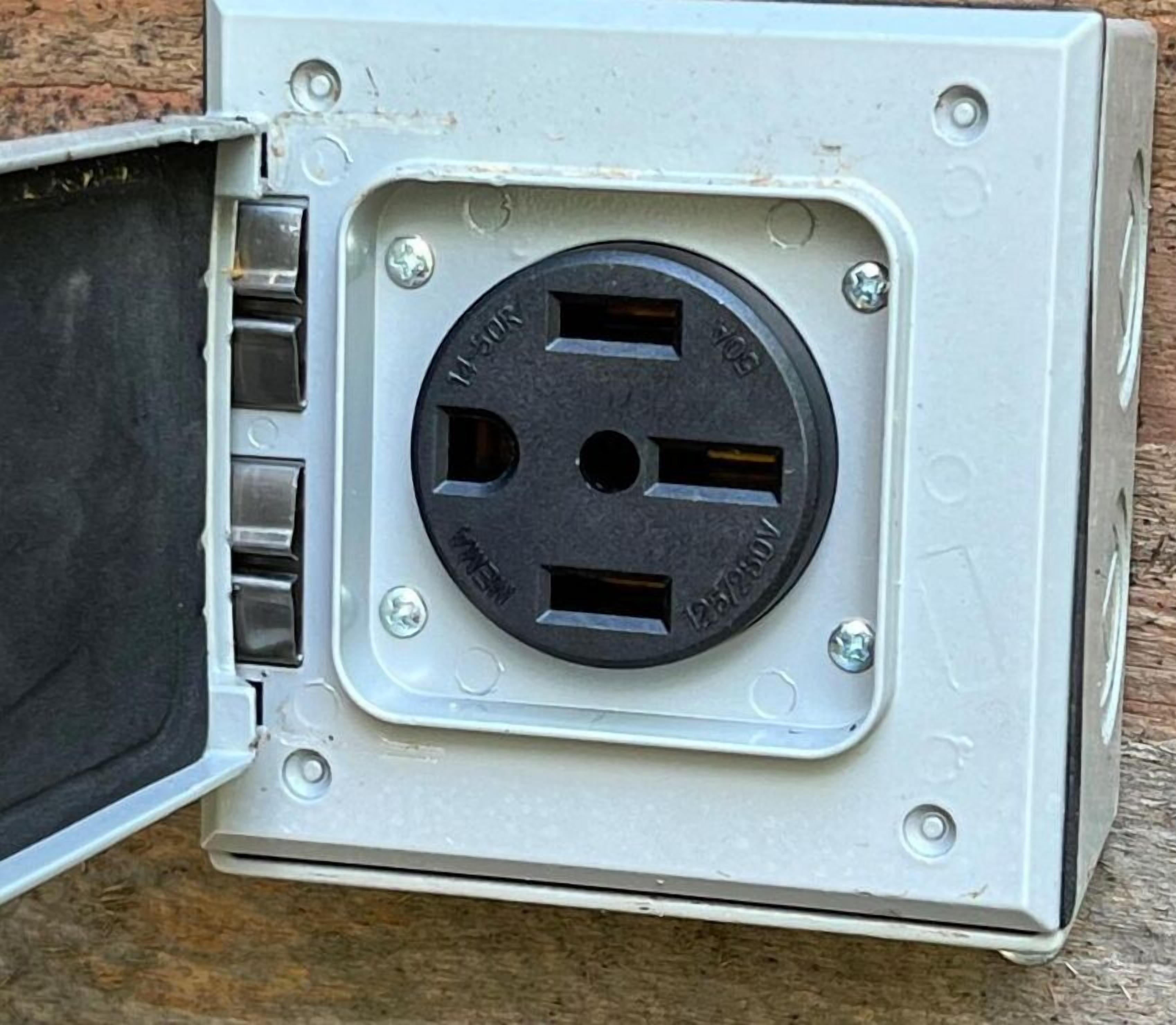 Una caja de servicios con una abertura circular, probablemente para conexiones eléctricas, fijada a una pared.