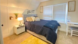A bedroom with a bed, bedside table, lamp, and a desk with a chair. - Sky in Portland Studio-Apartment across from OHSU (Portland)