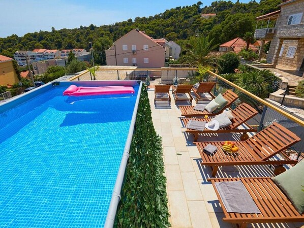 A swimming pool with lounge chairs and a view of surrounding buildings.