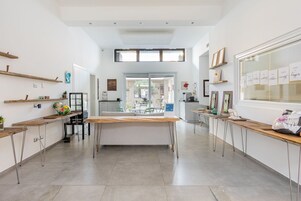 A modern kitchen with a central island, built-in shelves, and a large window.