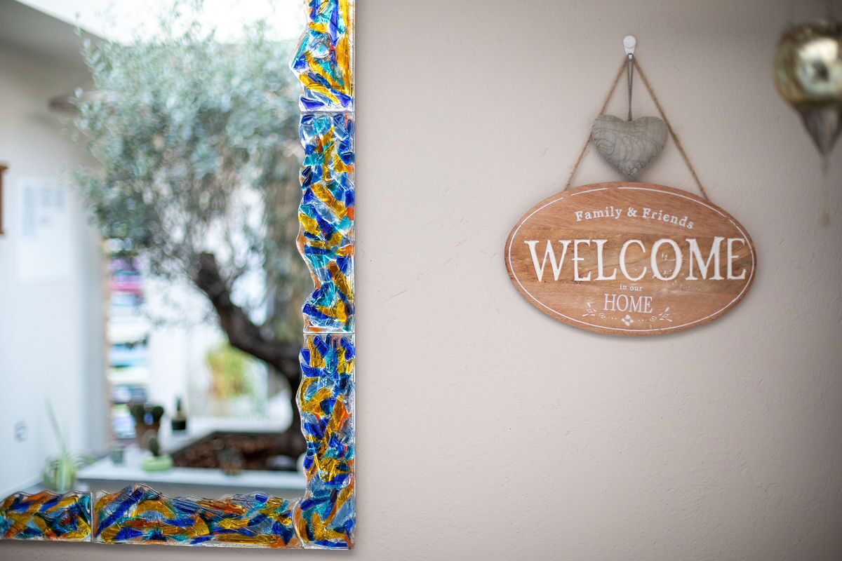 A welcome sign with "Family & Friends Welcome in our Home" on a wall.