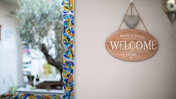 A welcome sign with "Family & Friends Welcome in our Home" on a wall.