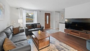 Un salon moderne avec un canapé, une table basse et un téléviseur.