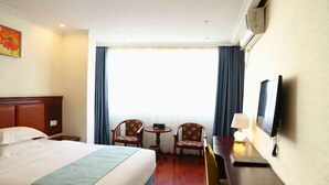 A hotel room with a bed, a desk, two chairs, a TV, and a window with curtains. - Xingyuexing Hotel (Zhuhai Gongbei Port) (Zhuhai)