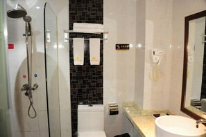 Un baño con ducha de vidrio, inodoro, lavamanos y espejo.