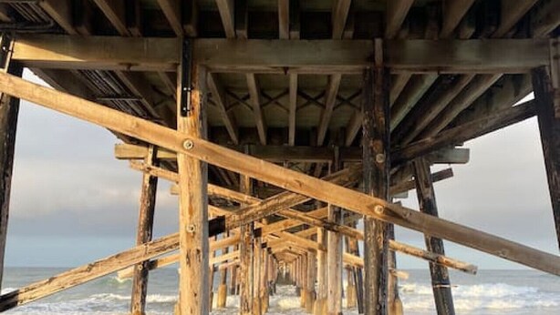 A wooden pier structure with a series of beams and supports extending into the water. - Back Unit · Beach House in the <3 of Balboa Peninsula (Newport Beach)