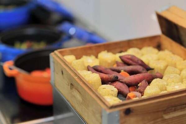 A wooden crate filled with yellow potatoes and red sweet potatoes.