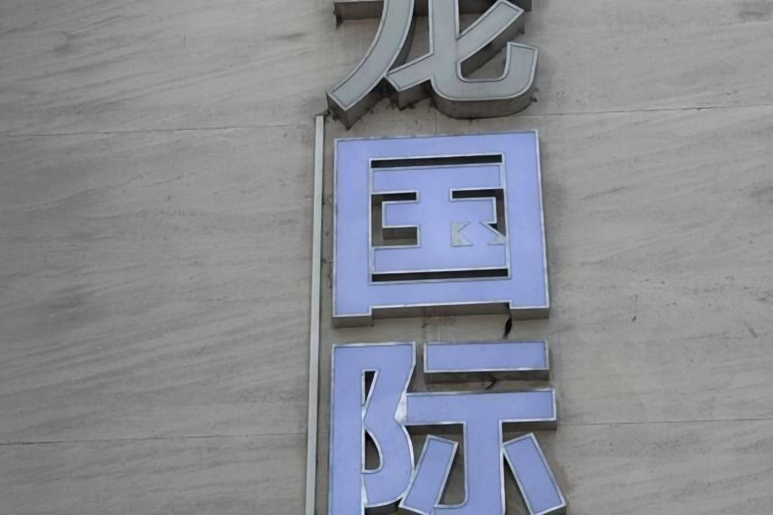 Une enseigne avec les caractères « 国 » et « 际 » sur un mur à texture.