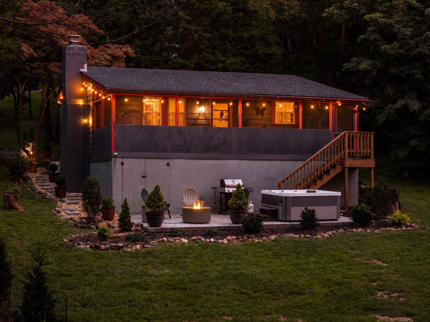 A modern house with a covered patio, outdoor seating, and a fireplace.