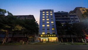 Un hotel de varios pisos con una entrada destacada y señalización.