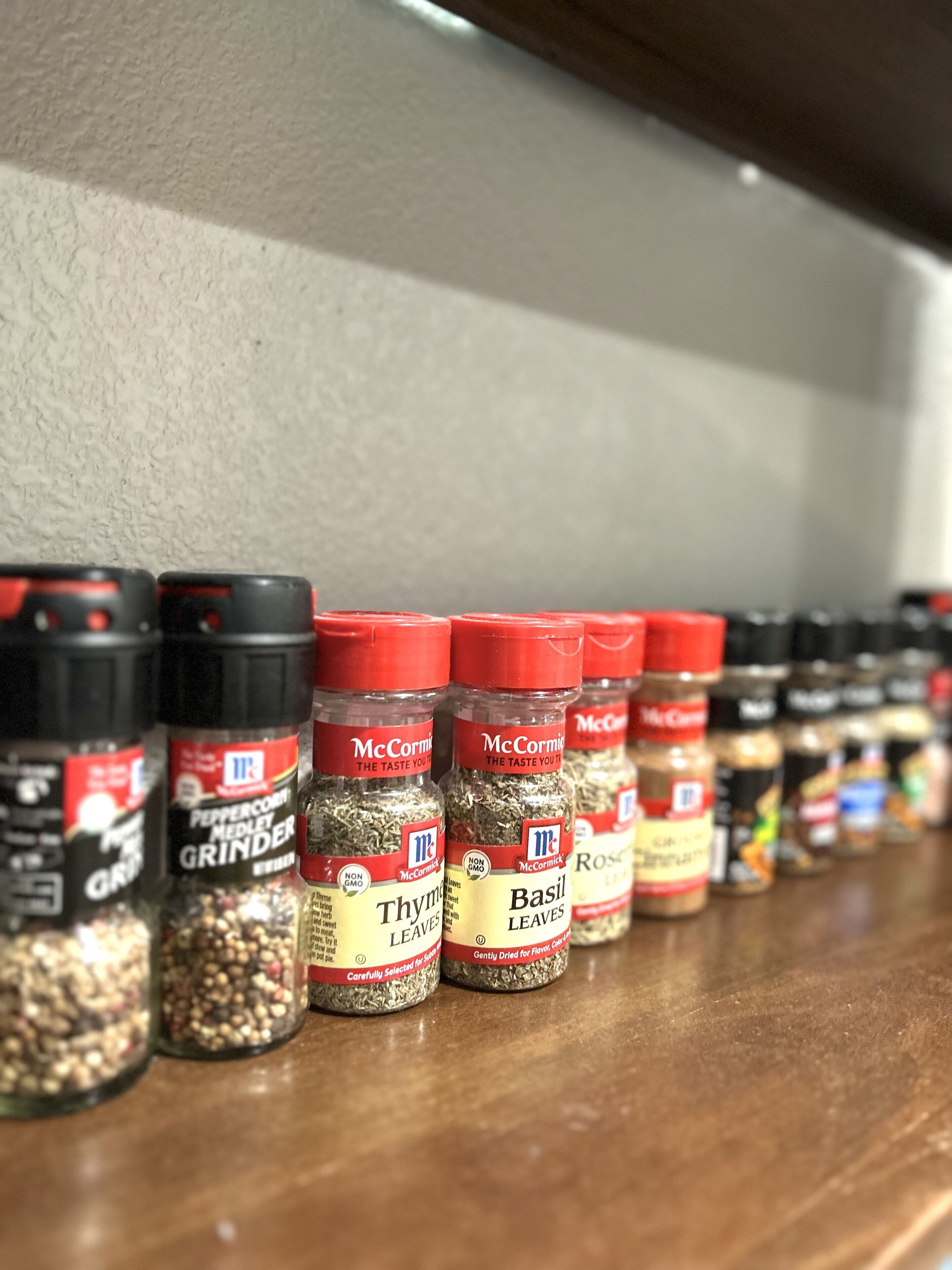 A row of spice jars on a shelf.