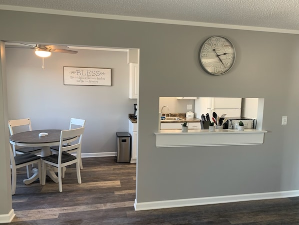A modern kitchen with a built-in oven, a clock, and a small island with kitchen tools.