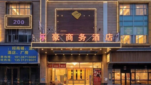 A hotel entrance with a neon sign, glass doors, and a visible address number. - Lehao Business Hotel (Foshan Lecong International Convention and Exhibition Center) (Foshan)