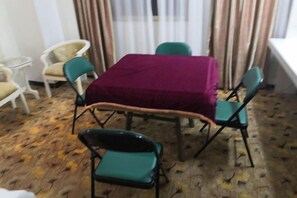A dining area with a table covered by a maroon tablecloth, surrounded by green chairs. - Lehao Business Hotel (Foshan Lecong International Convention and Exhibition Center) (Foshan)
