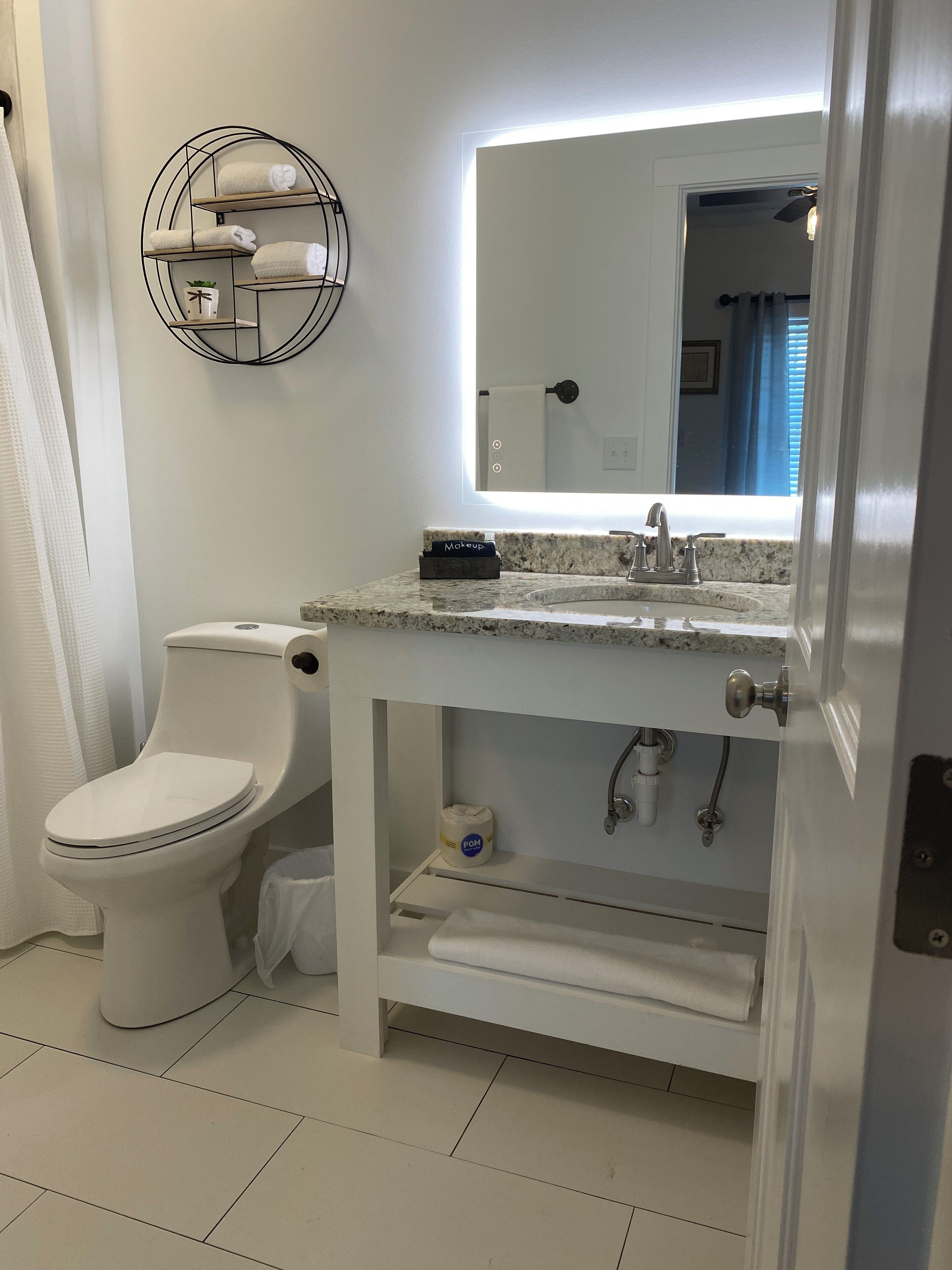 A modern bathroom with a toilet, sink, and mirror.