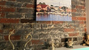 Two paintings of coastal scenes on a brick wall.