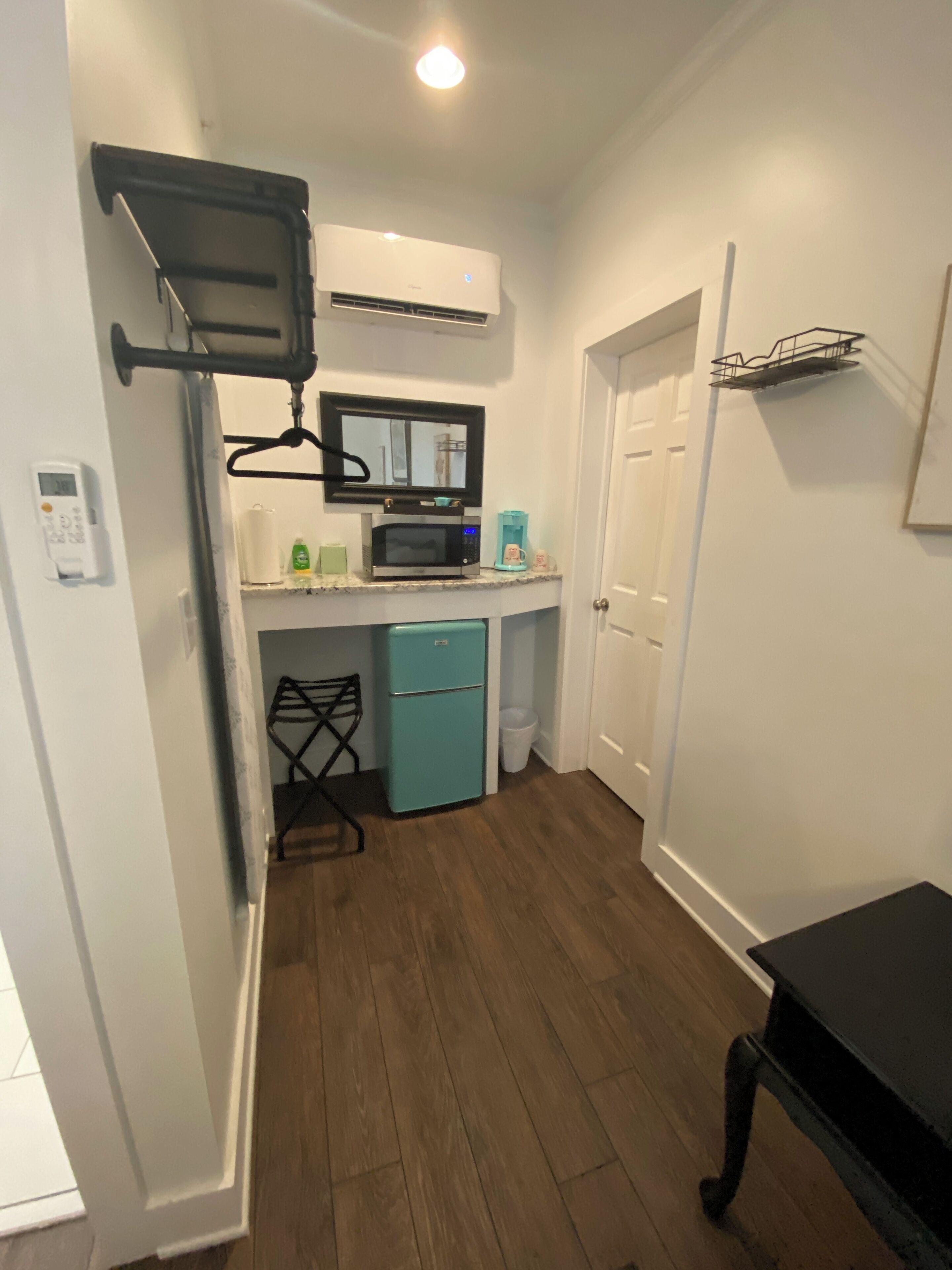A compact kitchen with a microwave, coffee maker, and a small refrigerator.