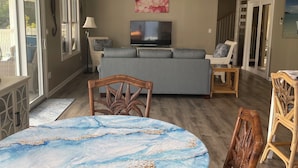 A spacious living area with a ceiling fan, a flat-screen TV, and a large window. -  Desert Rose Villa, with Fabulous Coral Harbor views (Coral Bay)