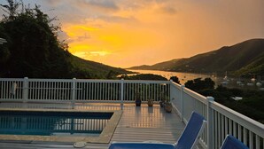 A deck with a pool, lounge chairs, and potted plants. -  Desert Rose Villa, with Fabulous Coral Harbor views (Coral Bay)