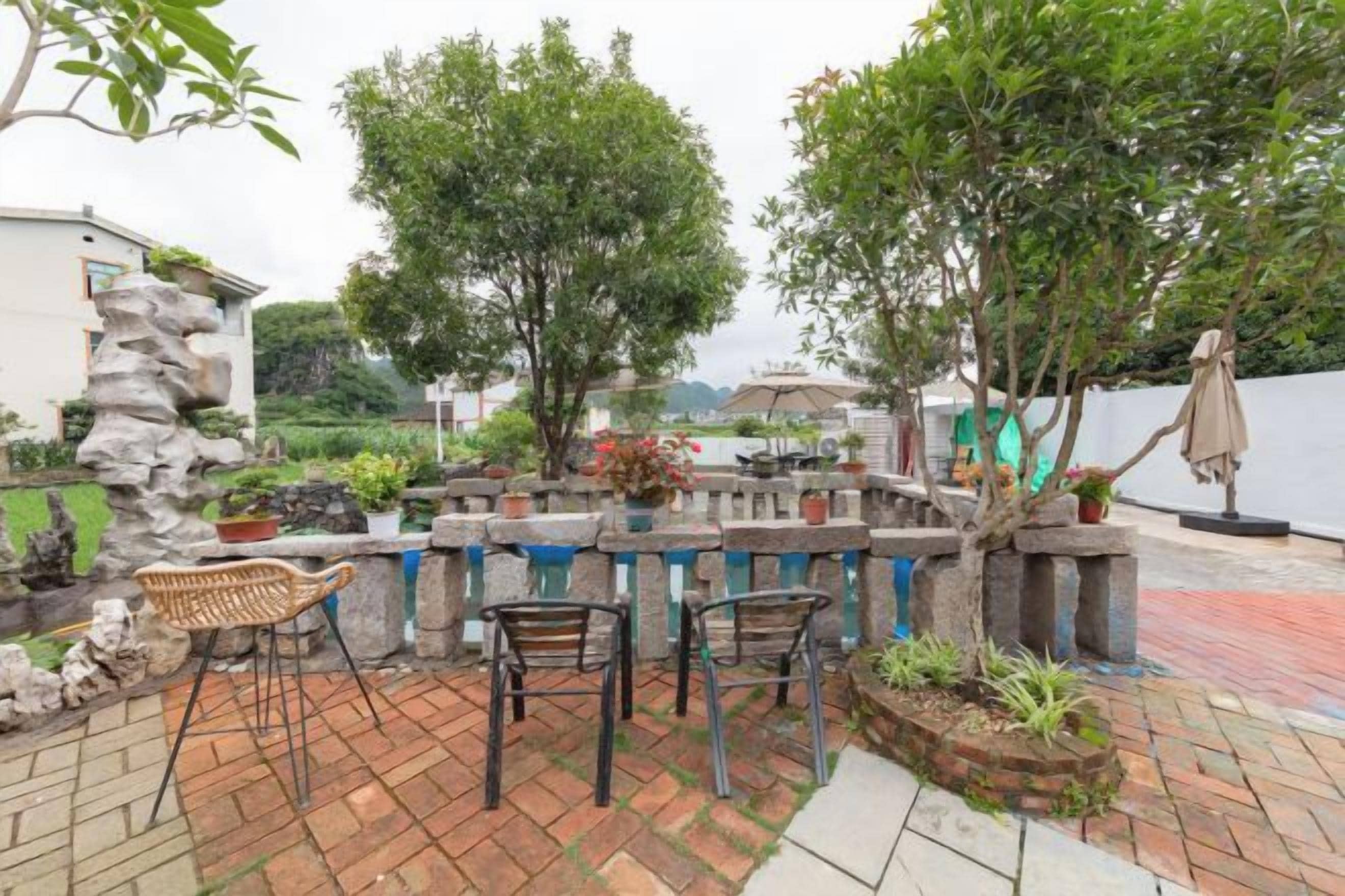 An outdoor patio with stone seating, a water feature, and a view of a body of water.
