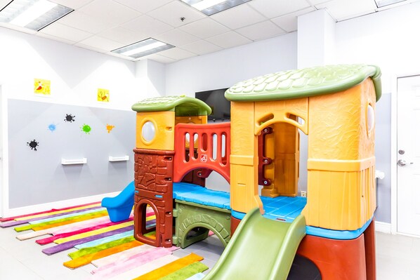 Een kinderspeelplaats met een glijbaan en klimconstructies.