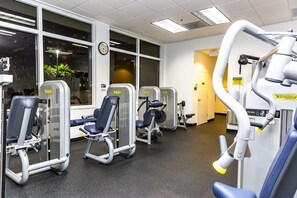 A gym with exercise machines, large windows, and a clock on the wall. - Brickell 1BR • City Views • Balcony • FREE Parking • Pool • Hot Tub • Gym (Miami)