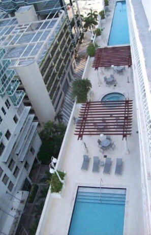 A modern building with a swimming pool, a gated entrance, and a covered outdoor area. - Brickell 1BR / City Views / Balcony / FREE Parking / Pool / Hot Tub / Gym (Miami)
