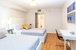 Een moderne slaapkamer met twee bedden, een bureau en een stoel.