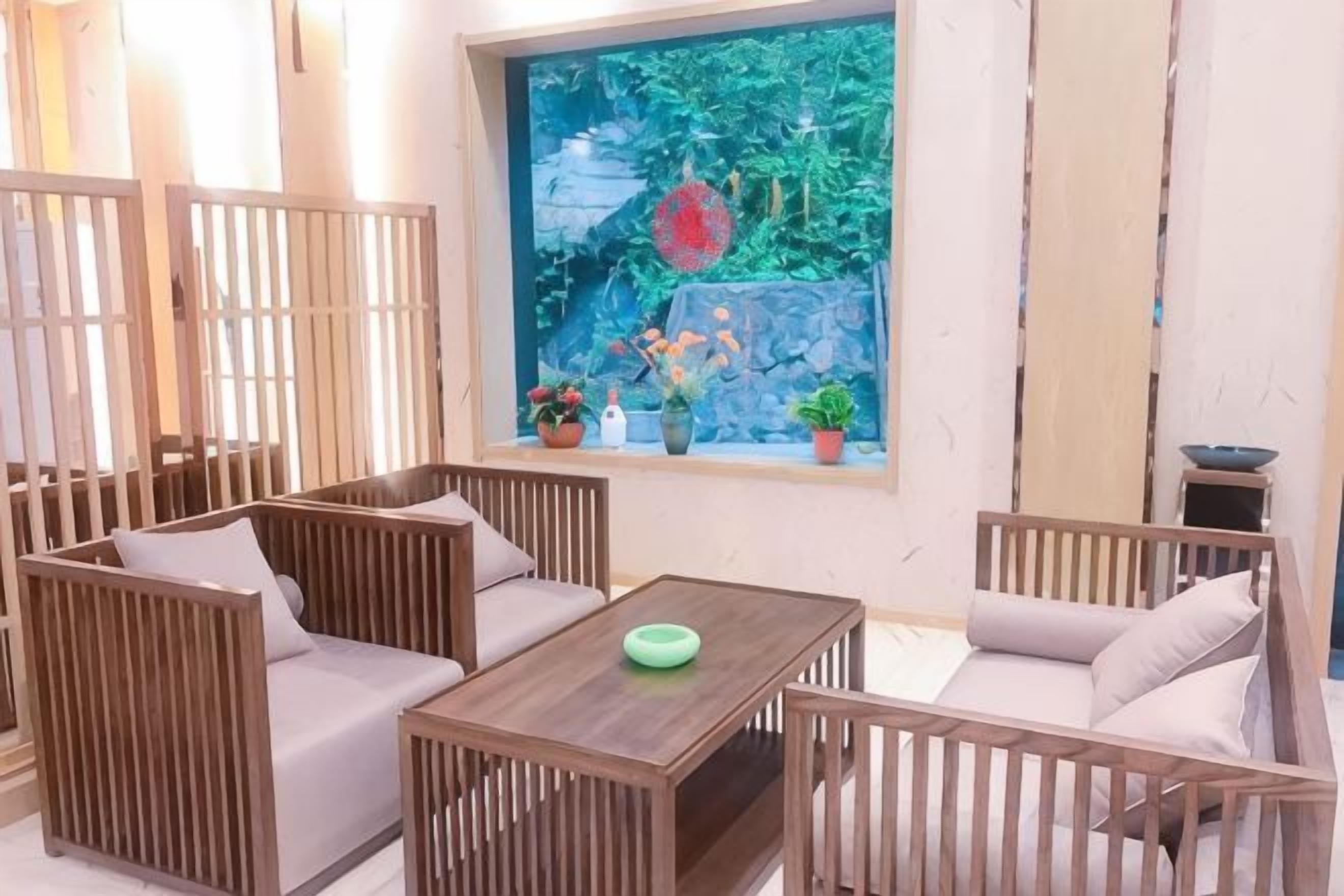 A room with a wooden sofa set, a small table, and a window with a view of a rock garden.