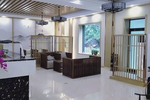 A modern hotel lobby with a reception desk, seating area, and large windows. - Liyang Nanshan Zhuhai Cuigu Manor Hotel (Liyang)