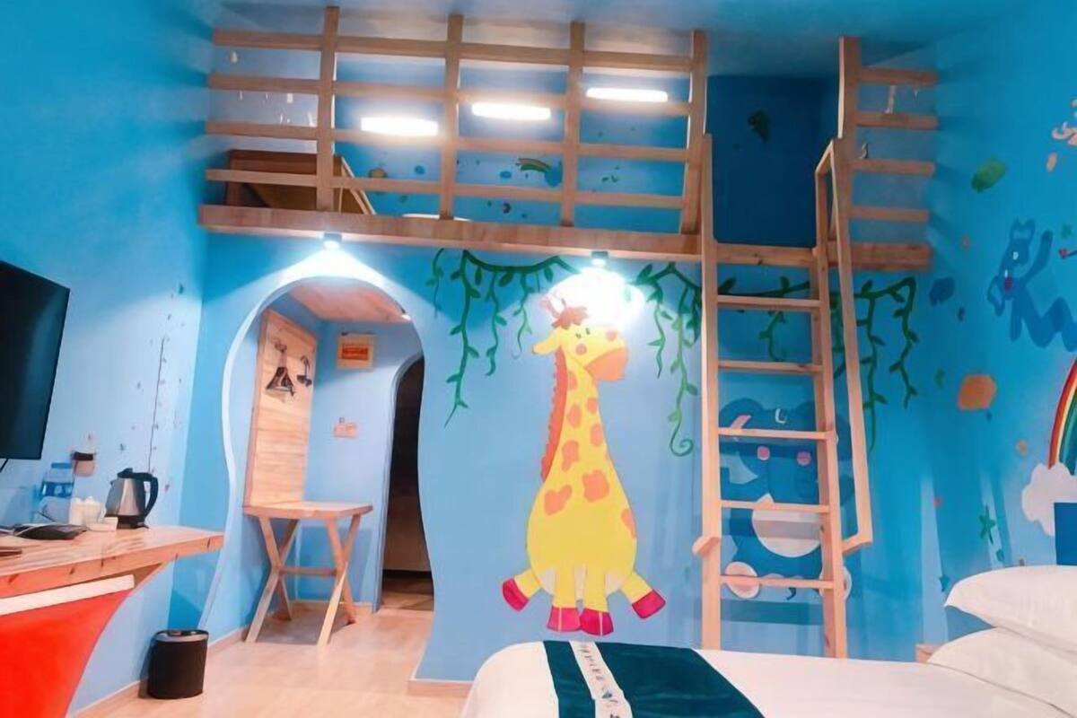 A room with a bunk bed, a desk, a chair, and a bed.