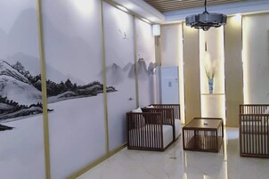Una habitación con un mural de montañas, una cama, una mesita de noche y una lámpara colgante.