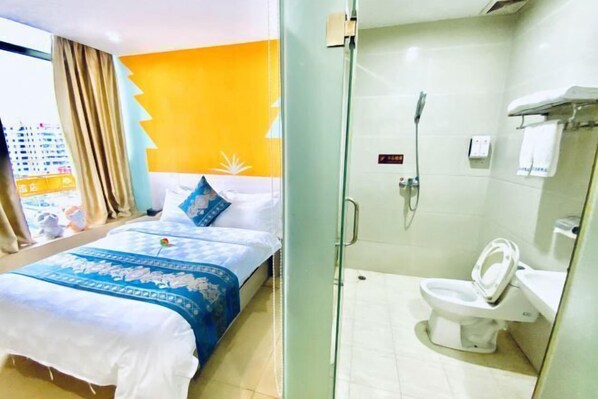 Een hotelkamer met een bed, een douche en een toilet.