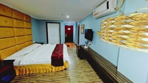 A hotel room with a bed, a television, and an air conditioning unit on the wall. - Yinhong Hostel (Kaiping)