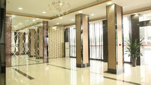A spacious lobby with a polished floor, large pillars, and a chandelier. - Yinhong Hostel (Kaiping)