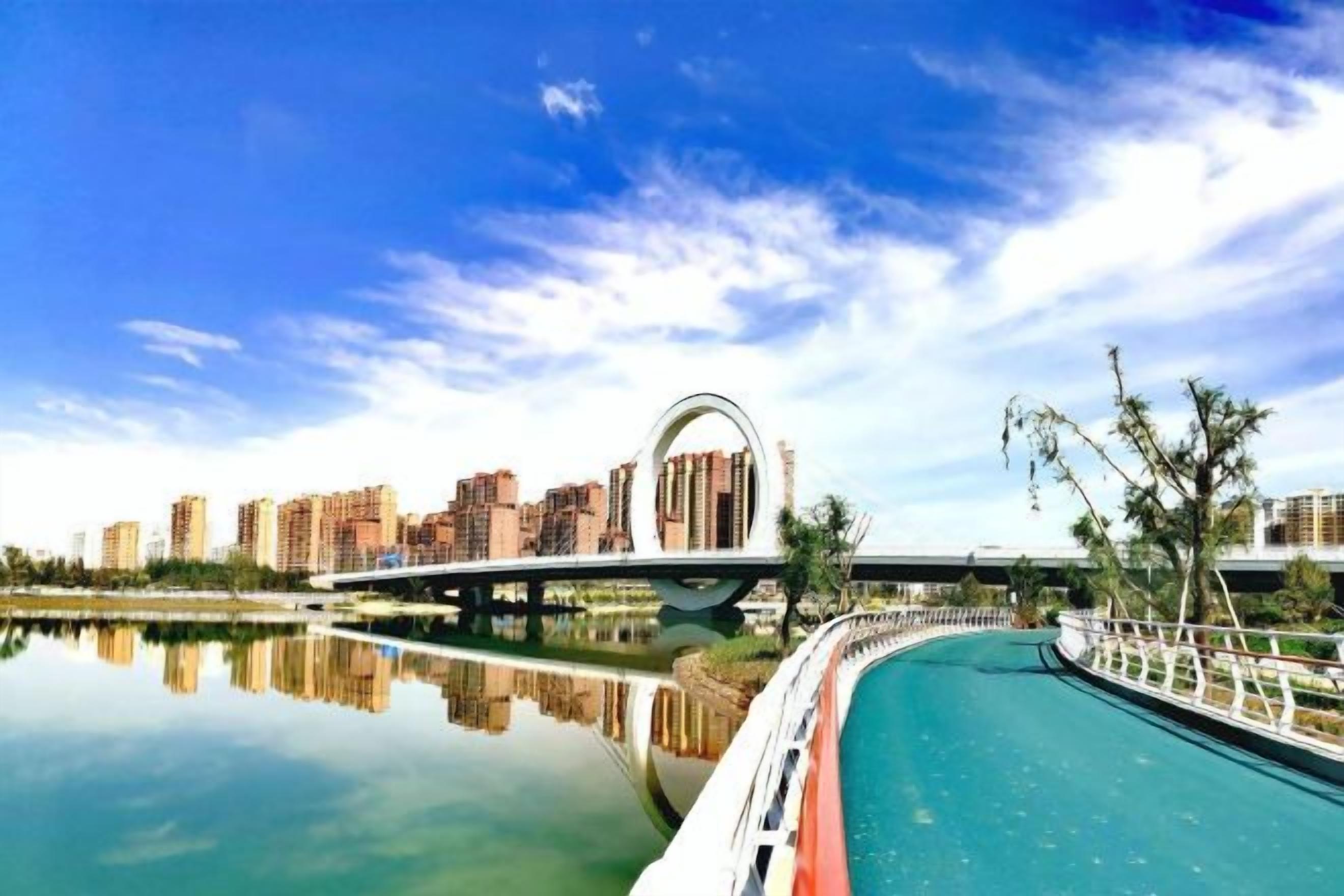 Vista sull'acqua con un ponte, edifici e una superficie d'acqua calma.