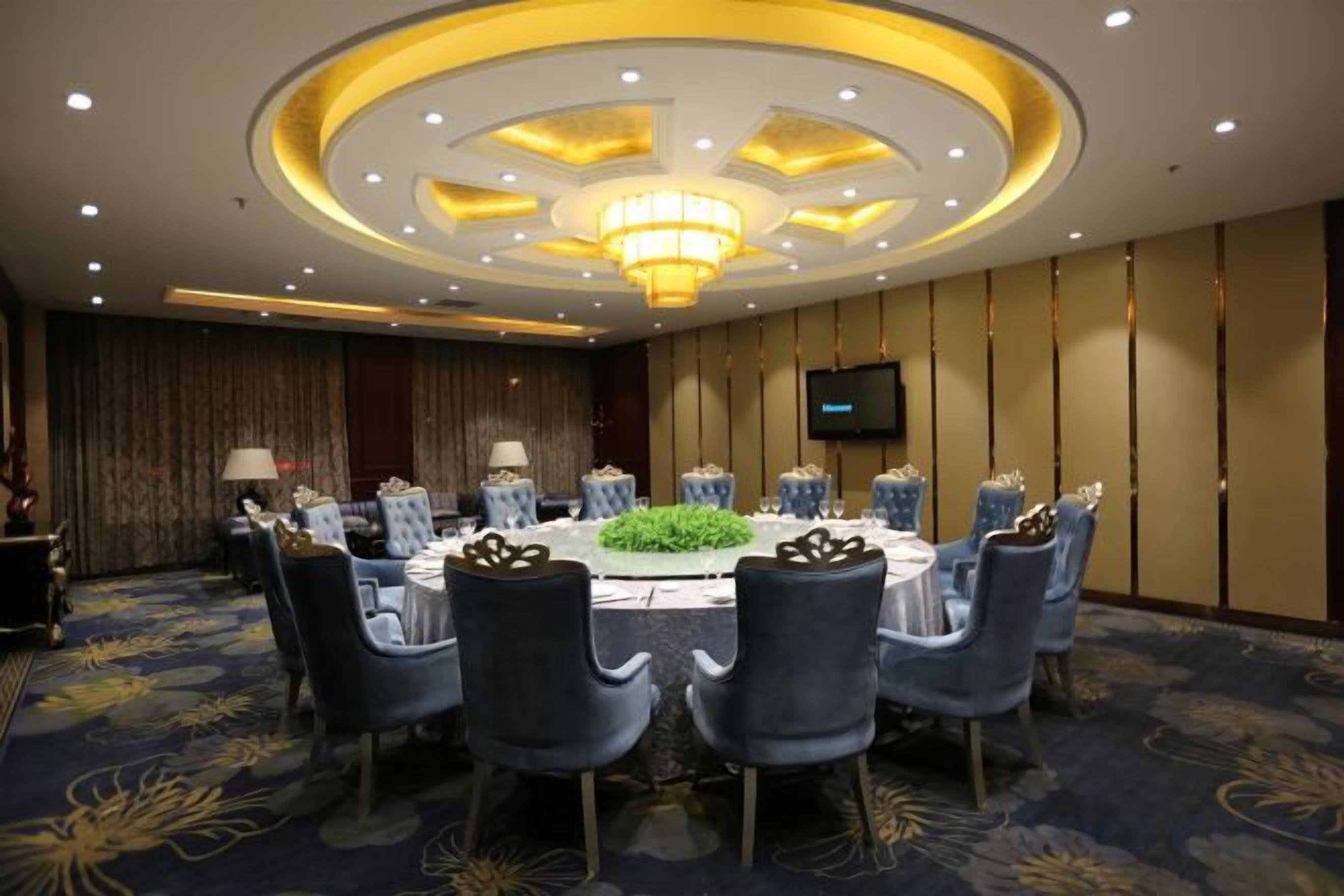 Ein Konferenzraum mit rundem Tisch, Stühlen und einer Chandelier.