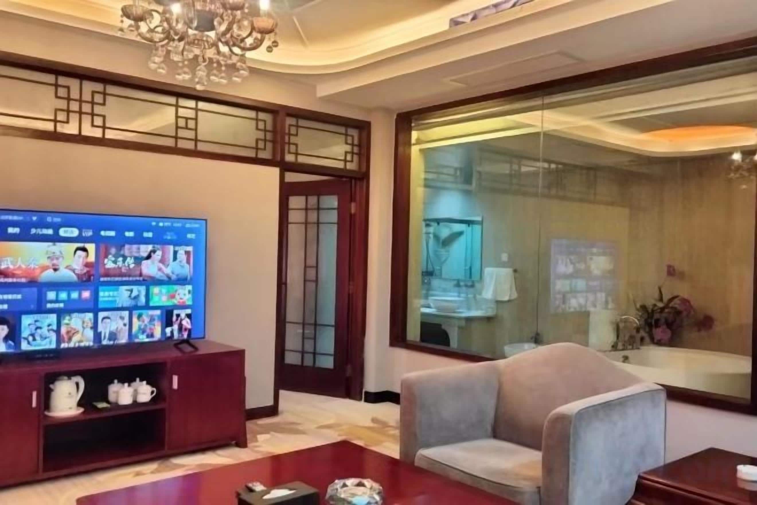 A modern living room with a flat-screen TV, a sofa, and a coffee table.