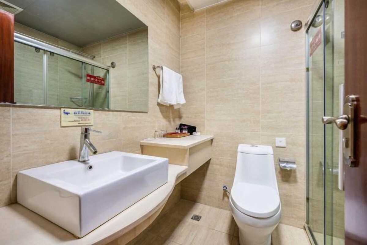 Een badkamer met een witte wastafel, toilet en een douchecabine van glas.