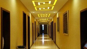 A hotel hallway with a modern design, featuring a long corridor with doors on both sides, a polished floor, and decorative lighting on the ceiling. - Zhangye Jiaheng International Hotel (Municipal Government & Big Buddha Temple Branch) (Zhangye)
