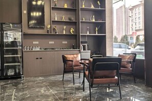 A modern interior with a marble floor, leather chairs, a bar area, and shelves with decorative items. - Zhangye Jiaheng International Hotel (Municipal Government & Big Buddha Temple Branch) (Zhangye)