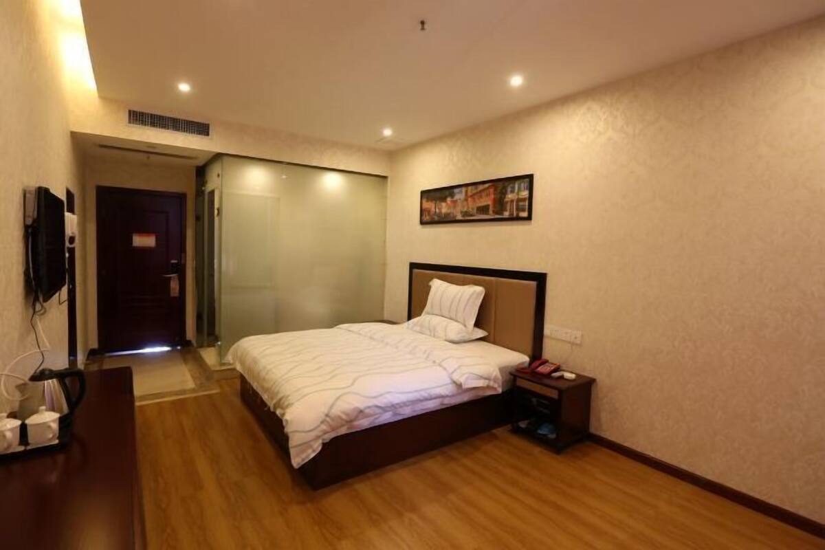 Ein Hotelzimmer mit Bett, Nachttisch und einem Bild an der Wand.