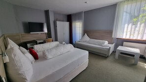 A hotel room with two beds, a TV, a desk, and a window with curtains. - MATZ Brunnenhof (Wilgartswiesen)
