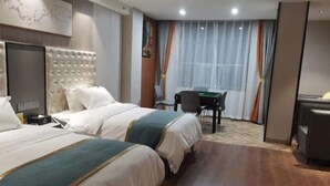 Ein Hotelzimmer mit zwei Betten, einem Schreibtisch und einem Stuhl.