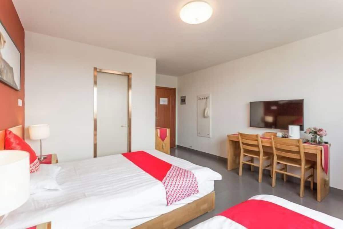 A hotel room with a bed, a desk, and a TV.