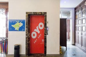 A hotel entrance with a red door labeled 'OYO' and a map on the wall. - Yuanlin Hotel (Suzhou)