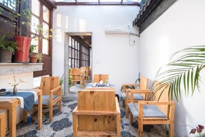 A room with wooden furniture, a small table, and potted plants. - Yuanlin Hotel (Suzhou)
